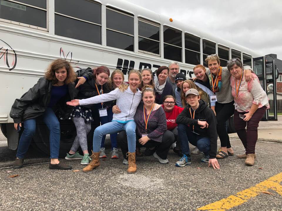 Youth being wonderfully silly in front of the bus